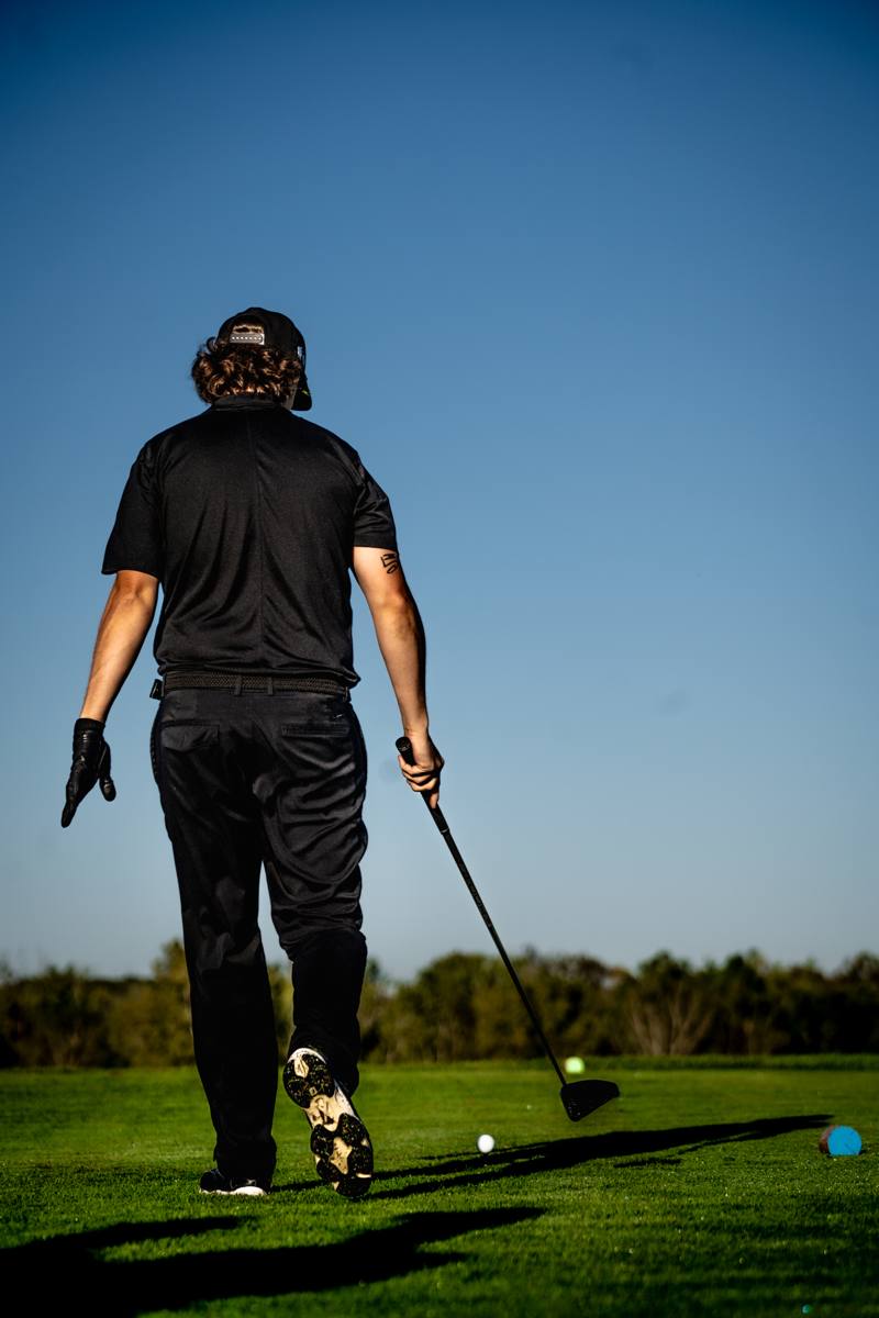 Golfer walking the fairway with club in hand during the Nomo Tour